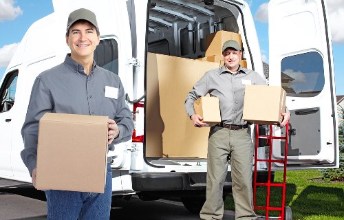 Staff using safe lifting techniques while carrying a boxed item